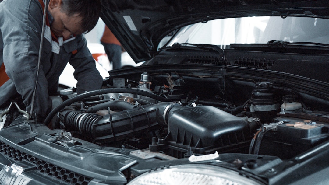 Mecánico revisando el motor de un automóvil ante dudas de compatibilidad con gasolina E10