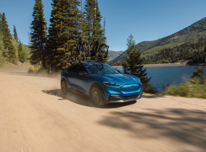 Ford Mustang Mach-E Trail 2027 circulando por camino de tierra con bicicletas en el techo