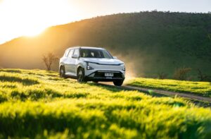 Kia EV5 blanco circulando por un camino entre cerros en Chile