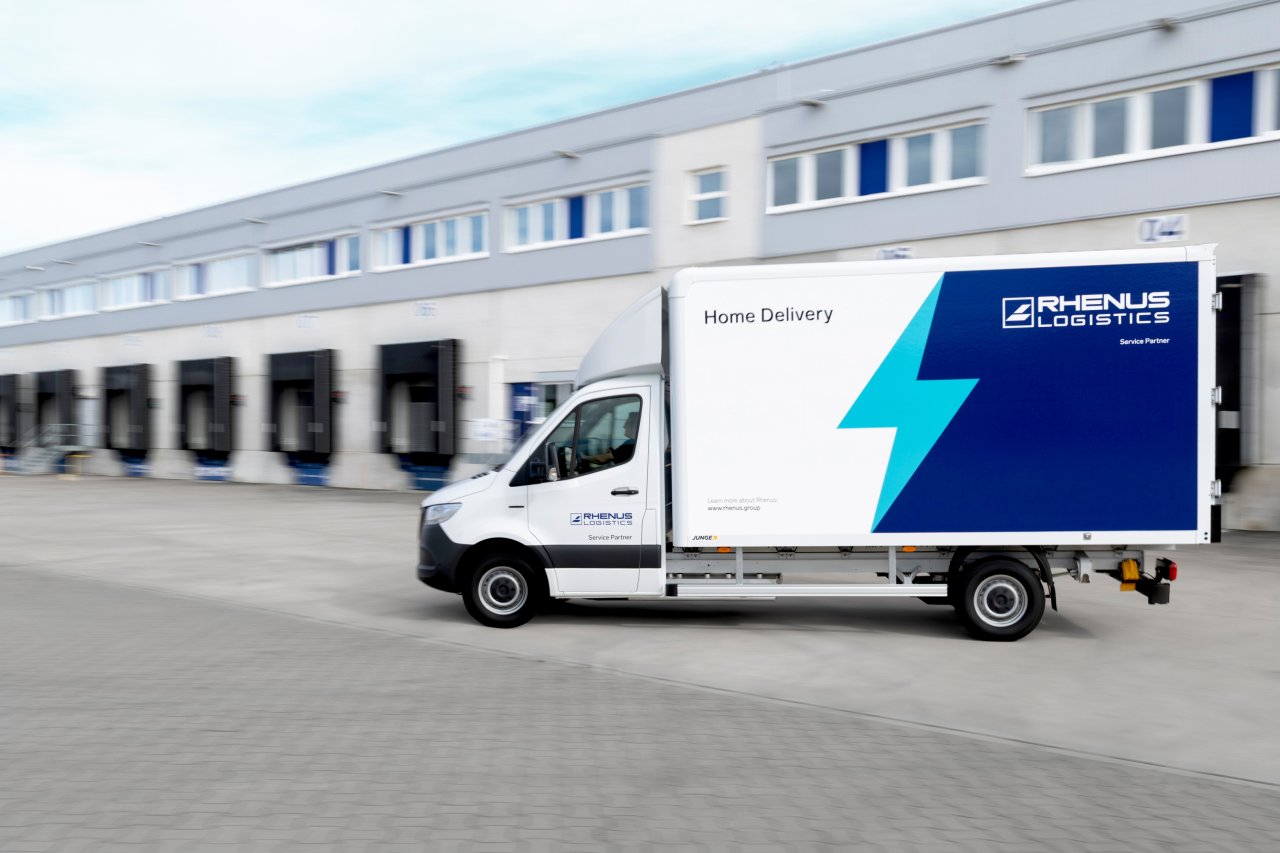 Mercedes-Benz eSprinter de Rhenus circulando junto a un centro logístico