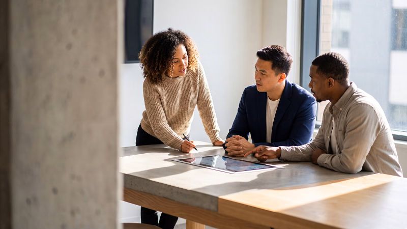 Ilustración generada con IA de tres personas trabajando, difundida por PwC para su encuesta laboral